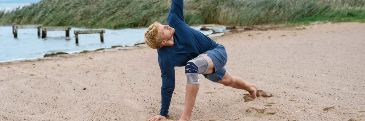 Mann am Strand beim Stretching